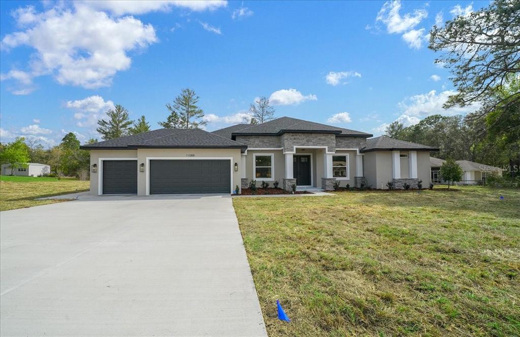 11088 Fulton Avenue Weeki Wachee, FL 34613 - Photo 59 of 63 a front view of a house with a garden and yard
