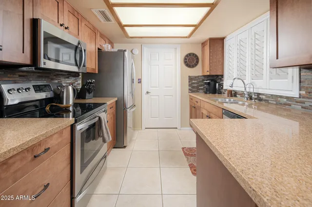 a kitchen with stainless steel appliances granite countertop a stove a sink and a refrigerator