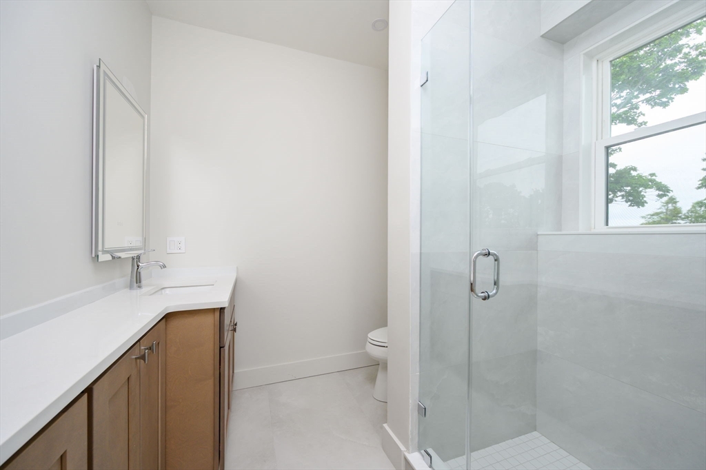 21 Tanglewood Road, Unit 3 Boston, MA 02126 - Photo 18 of 22 a bathroom with a granite countertop sink toilet and shower