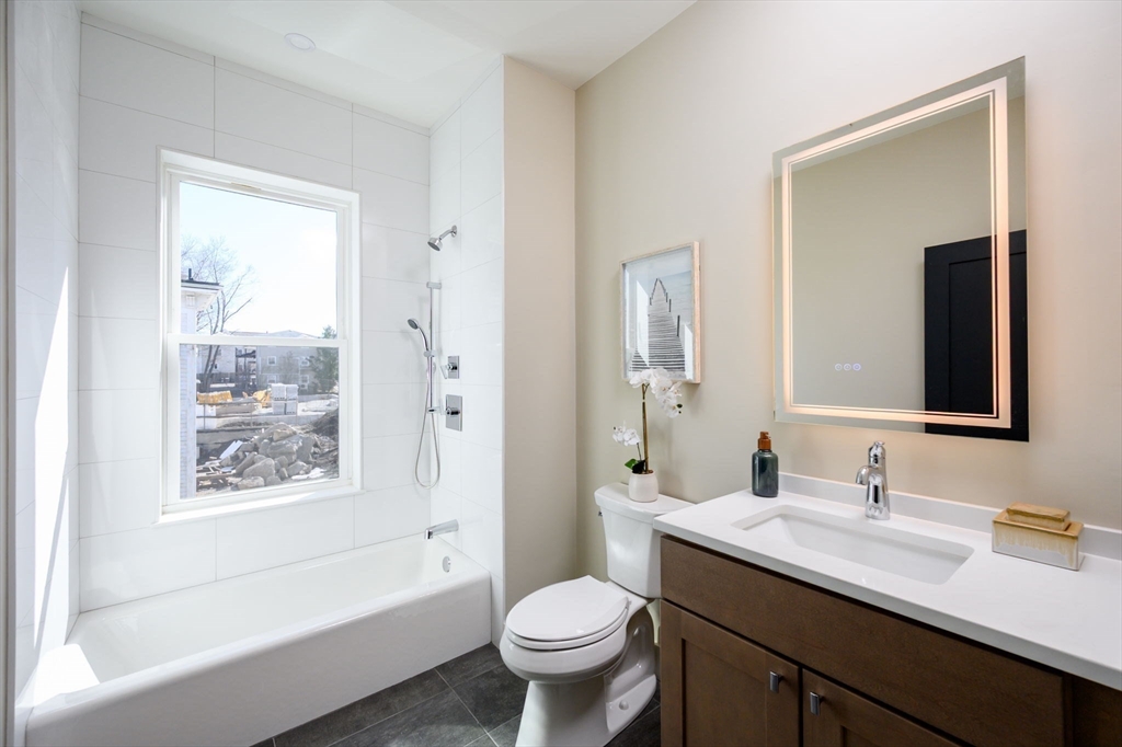 21 Tanglewood Road, Unit 3 Boston, MA 02126 - Photo 20 of 22 a bathroom with a granite countertop toilet a sink and a bathtub