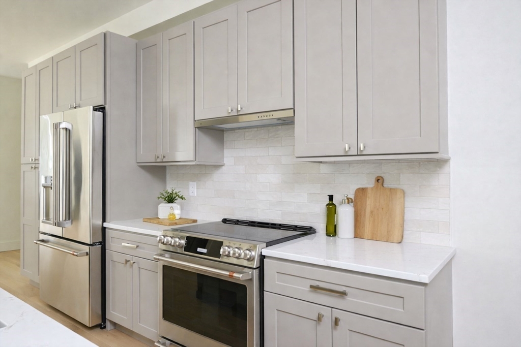21 Tanglewood Road, Unit 3 Boston, MA 02126 - Photo 2 of 22 a kitchen with stainless steel appliances granite countertop a refrigerator stove and white cabinets