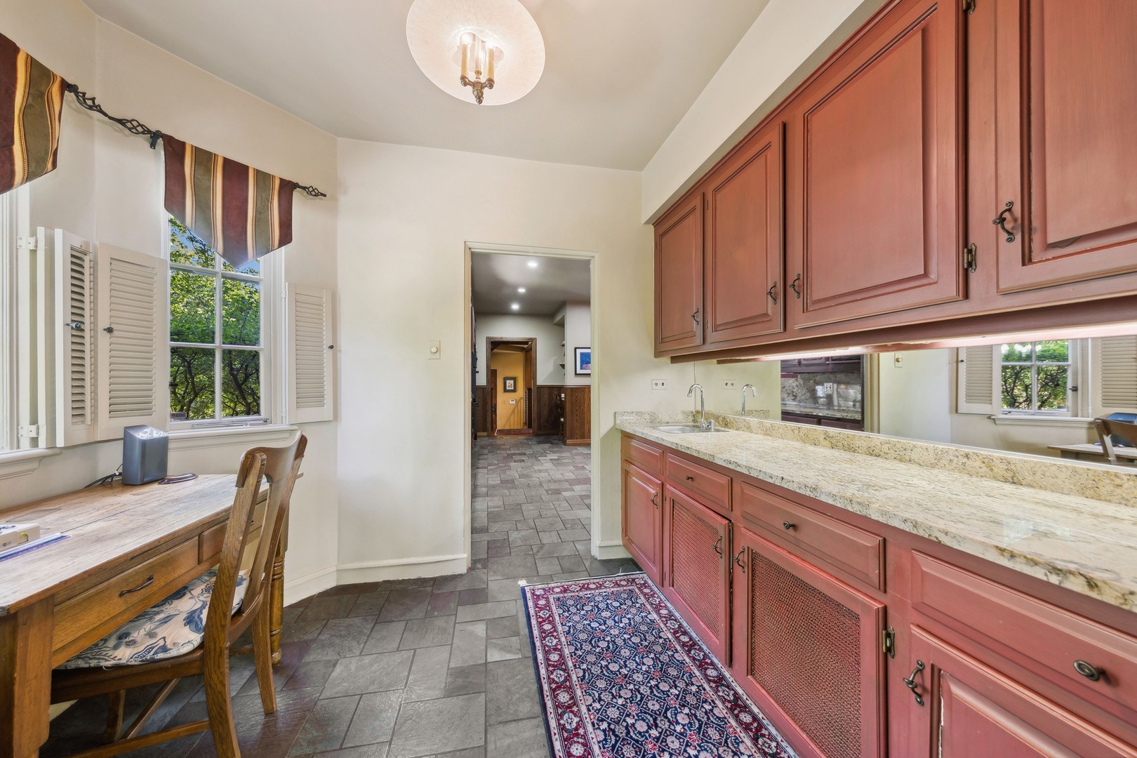 719 South County Line Road Hinsdale, IL 60521 - Photo 17 of 52 a kitchen with granite countertop wooden cabinets a sink a stove a dining table and chairs