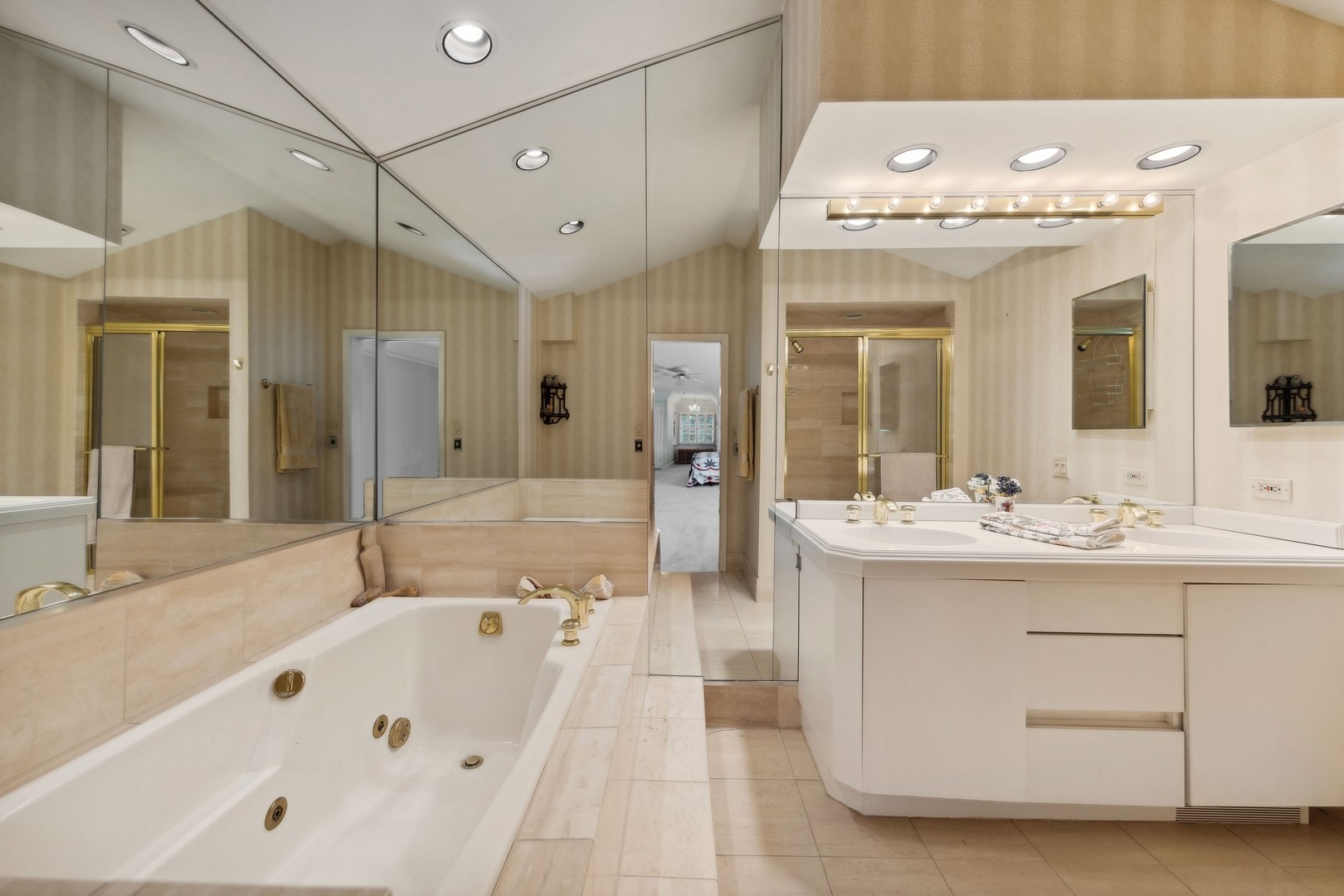 719 South County Line Road Hinsdale, IL 60521 - Photo 35 of 52 a bathroom with a bathtub a double vanity sink and mirror