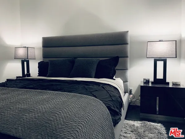 a bedroom with a bed and lamp on table