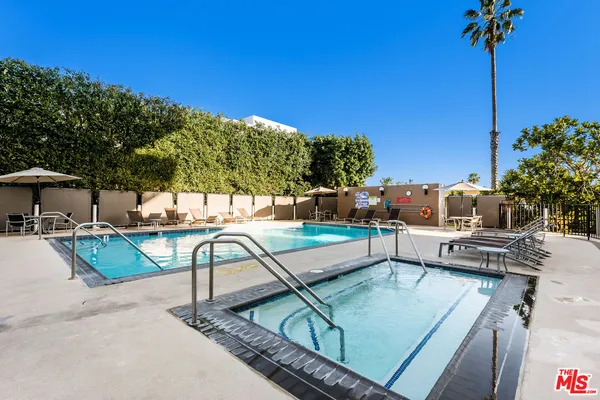 a view of a patio with a table and chairs under an umbrella with potted plants