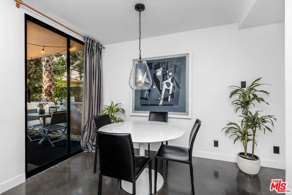 a dining room with furniture potted plants and wooden floor