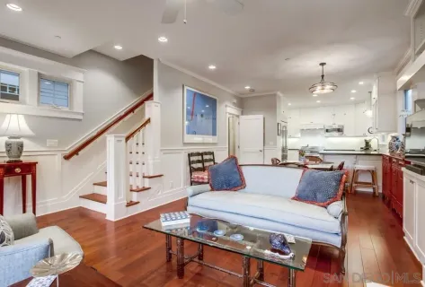 a dining room with furniture a chandelier and wooden floor