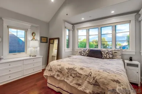 a bedroom with a bed and painting on the wall