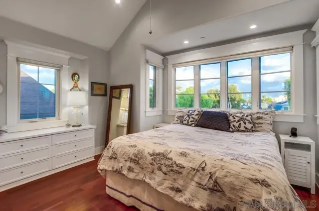 a bedroom with a bed and painting on the wall