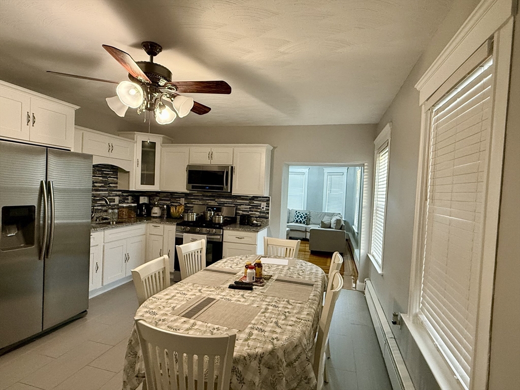 142 Cote Avenue Woonsocket, RI 02895 - Photo 12 of 22 a kitchen with kitchen island a large counter space appliances and a ceiling fan
