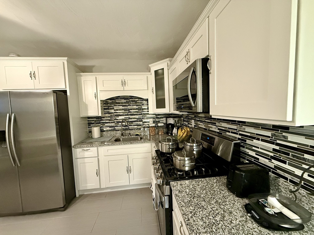 142 Cote Avenue Woonsocket, RI 02895 - Photo 3 of 22 a kitchen with a sink a stove and refrigerator