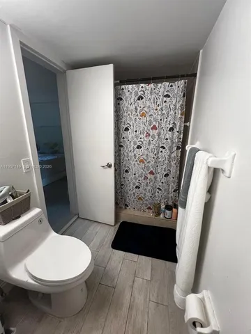 a bathroom with a toilet and a shower