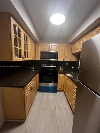 a kitchen with granite countertop a refrigerator and a stove