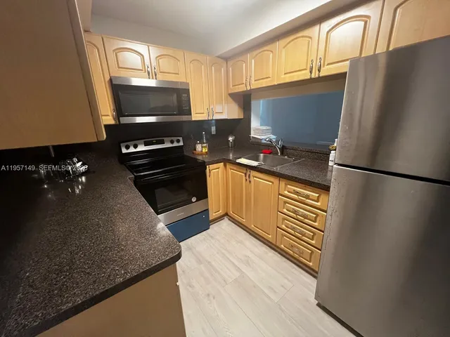 a kitchen with a refrigerator and a stove top oven