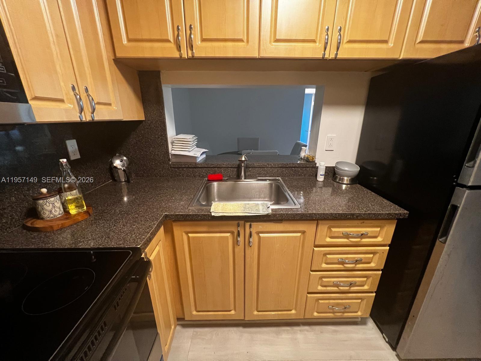 11750 Southwest 18th Street, Unit 1251 Miami, FL 33175 - Photo 6 of 15 a kitchen with granite countertop a sink and a stove