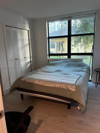 a bedroom with a bed and a large window