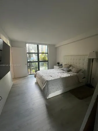 a bed sitting in a bedroom next to a window