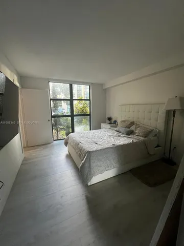 a bed sitting in a bedroom next to a window