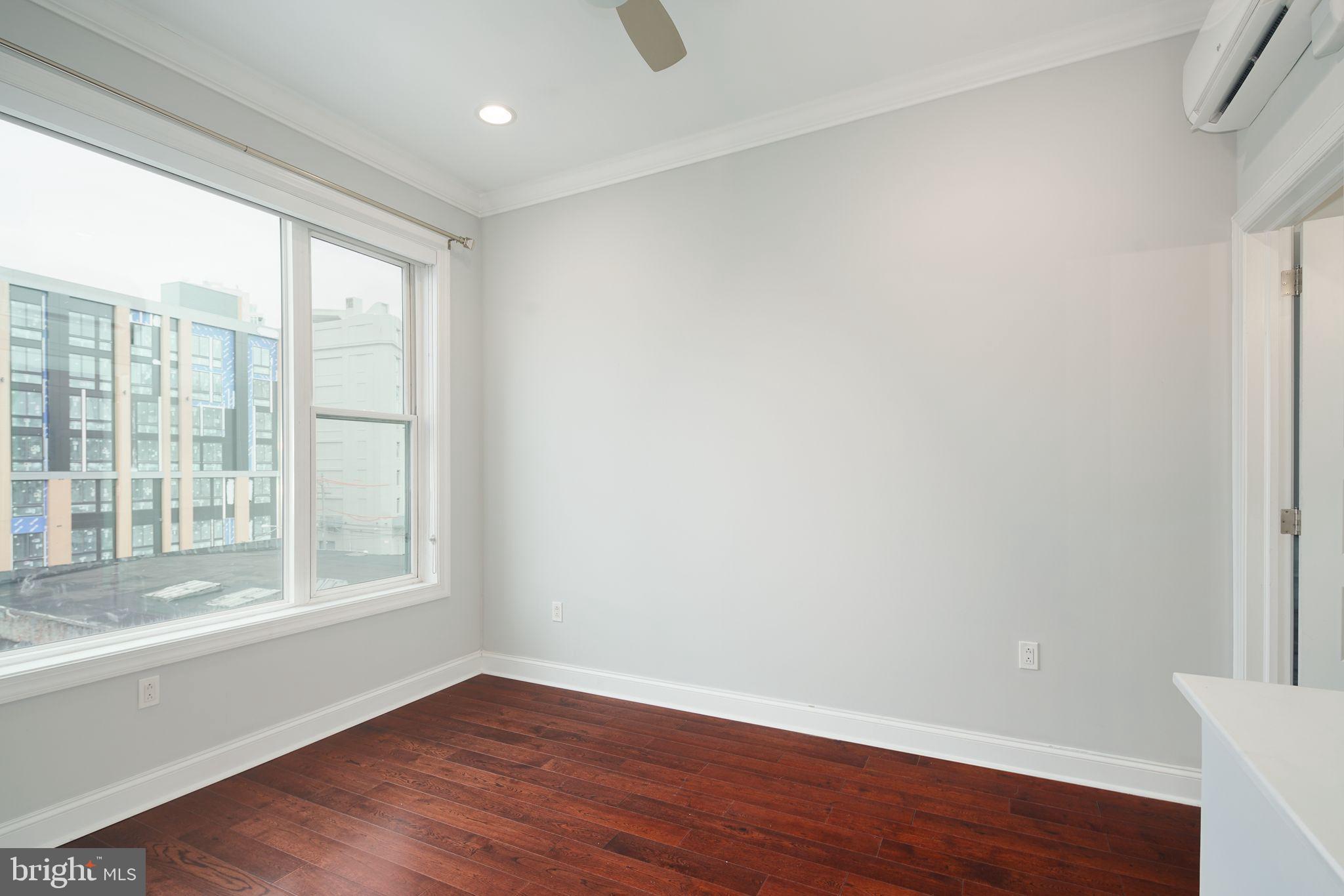 901 North Front Street, Unit 5 Philadelphia, PA 19123 - Photo 5 of 12 a view of an empty room with wooden floor and a window