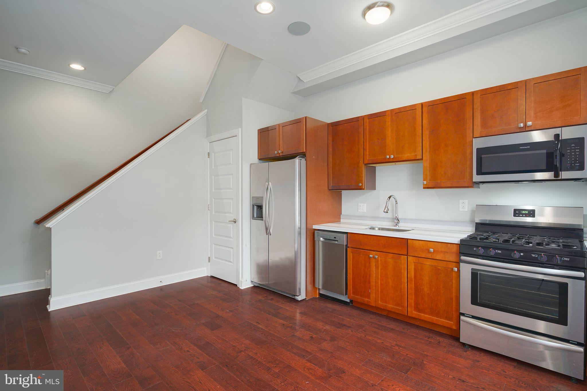 901 North Front Street, Unit 5 Philadelphia, PA 19123 - Photo 10 of 12 a kitchen with wooden floors and stainless steel appliances