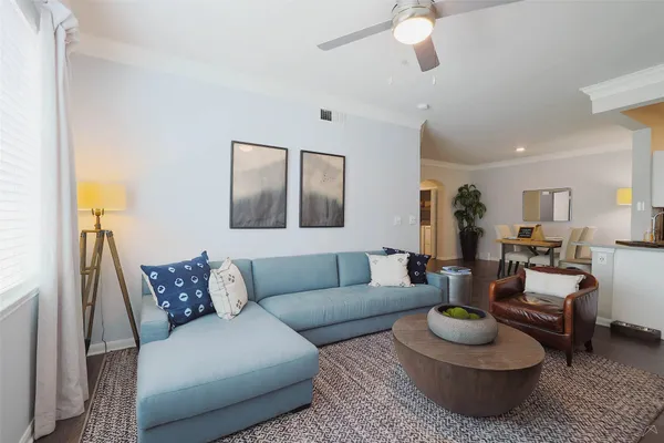 a living room with furniture and a wooden floor
