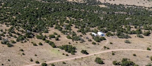 a view of a dry yard covered with snow in the background