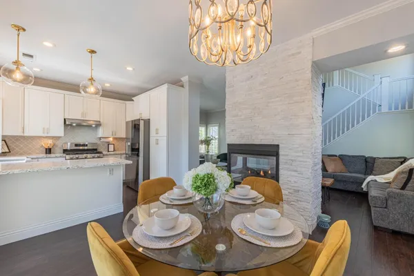 a kitchen with stainless steel appliances kitchen island granite countertop a stove a kitchen island and chairs