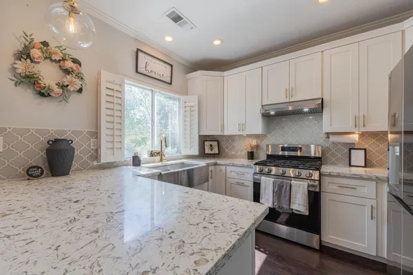 a kitchen with stainless steel appliances kitchen island granite countertop a refrigerator stove top oven and sink