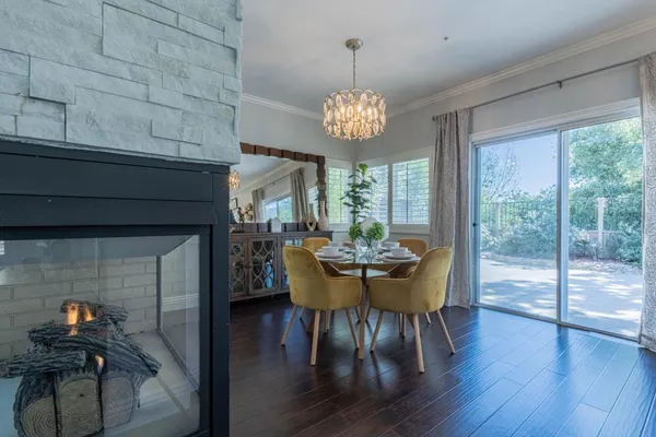 a view of a dining room with furniture a chandelier and wooden floor