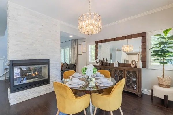 a dining room with furniture a fireplace and wooden floor