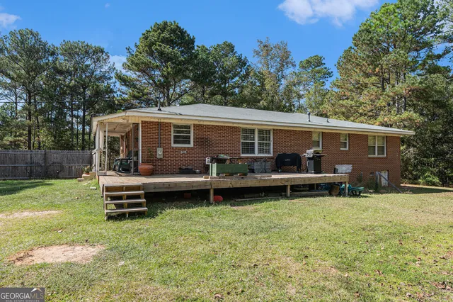 a view of a house with backyard sitting area and garden