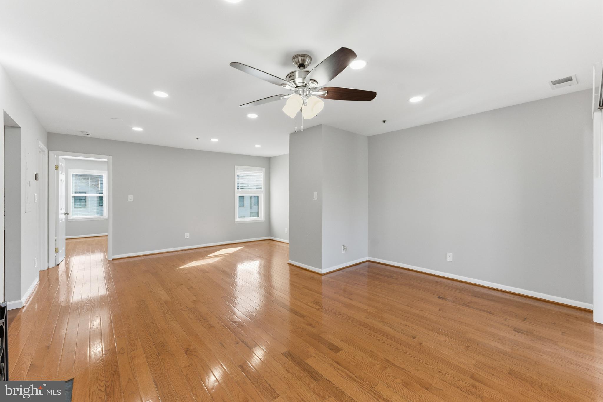 13406 Shady Knoll Drive, Unit 305 Silver Spring, MD 20904 - Photo 12 of 37 a view of an empty room with wooden floor and a ceiling fan