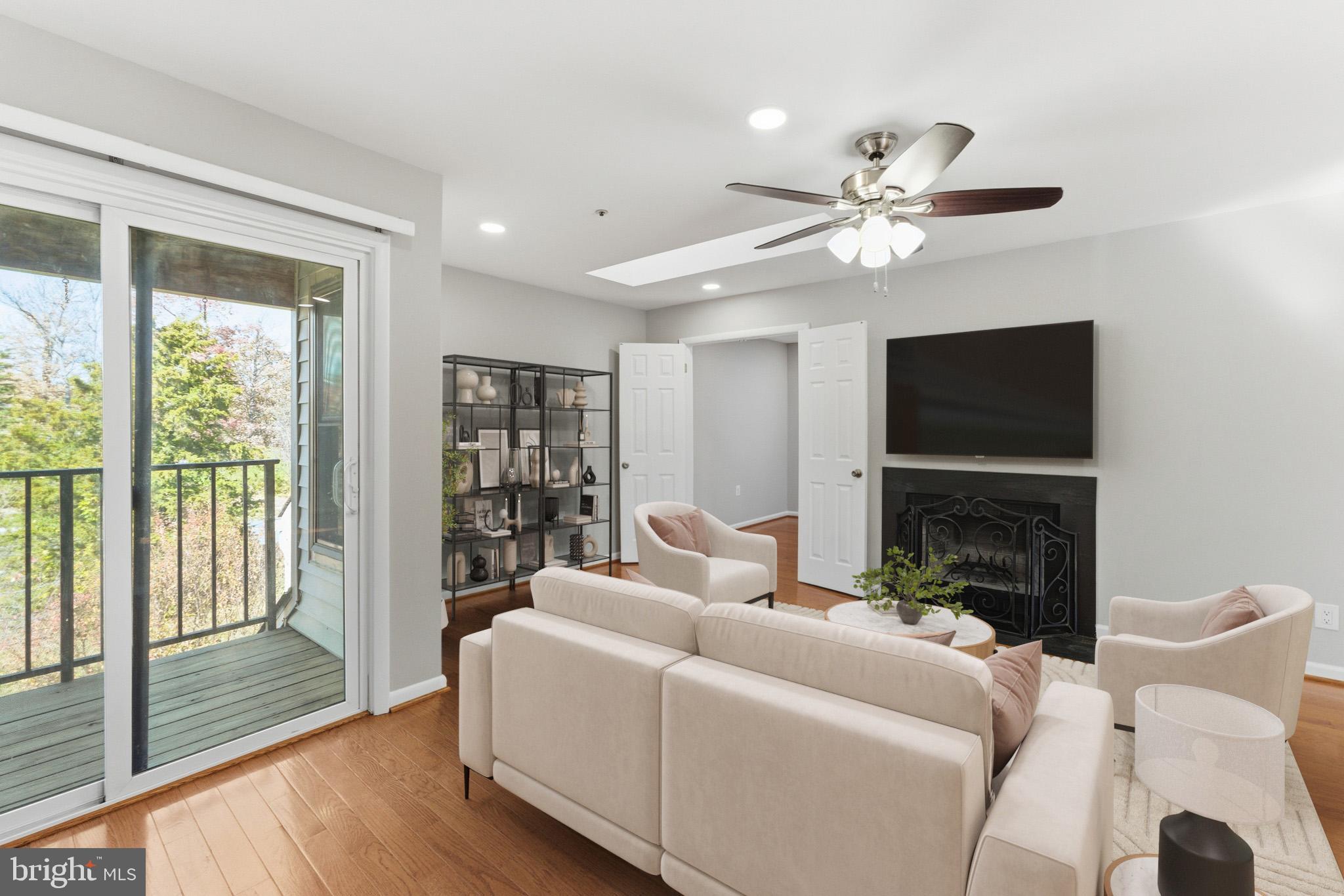 13406 Shady Knoll Drive, Unit 305 Silver Spring, MD 20904 - Photo 13 of 37 a living room with furniture a fireplace and a flat screen tv