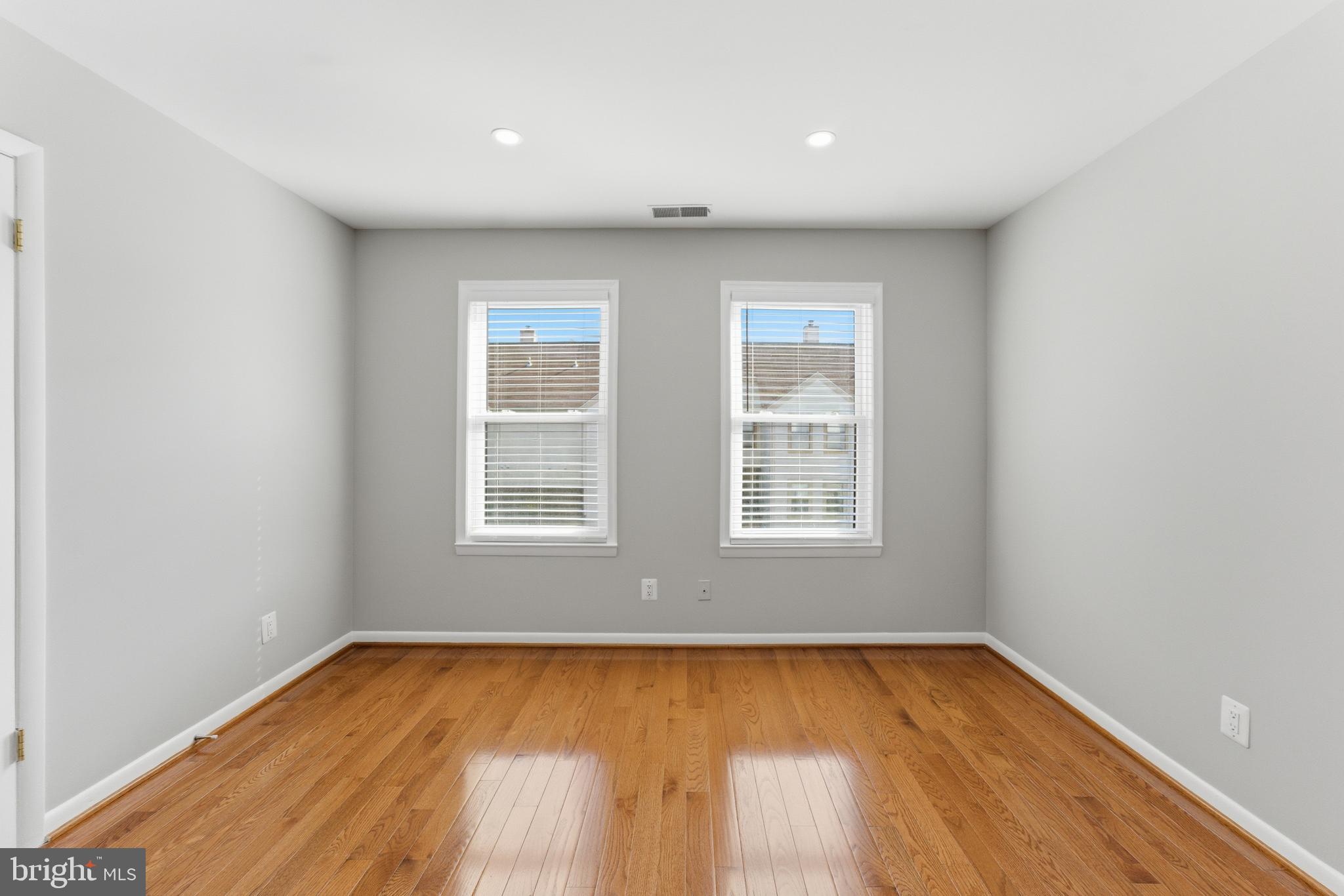 13406 Shady Knoll Drive, Unit 305 Silver Spring, MD 20904 - Photo 29 of 37 an empty room with wooden floor and windows