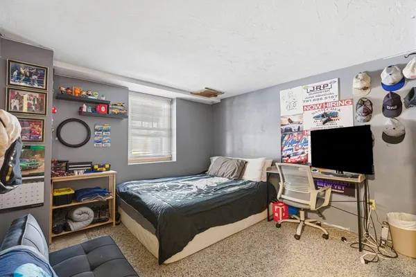 a bedroom with a bed and a flat tv screen on the wall