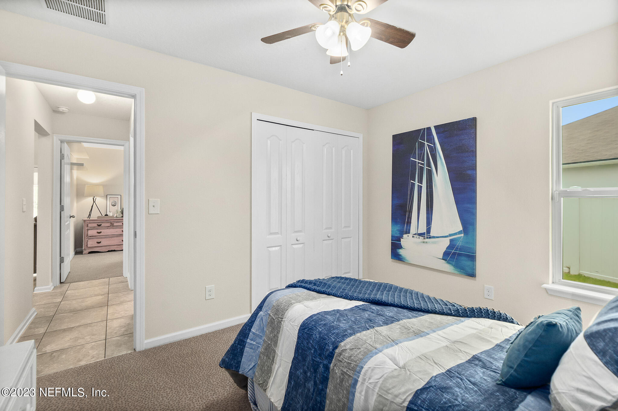 598 Deer Crossing Road St. Augustine, FL 32086 - Photo 24 of 33 a bedroom with a bed and a chandelier