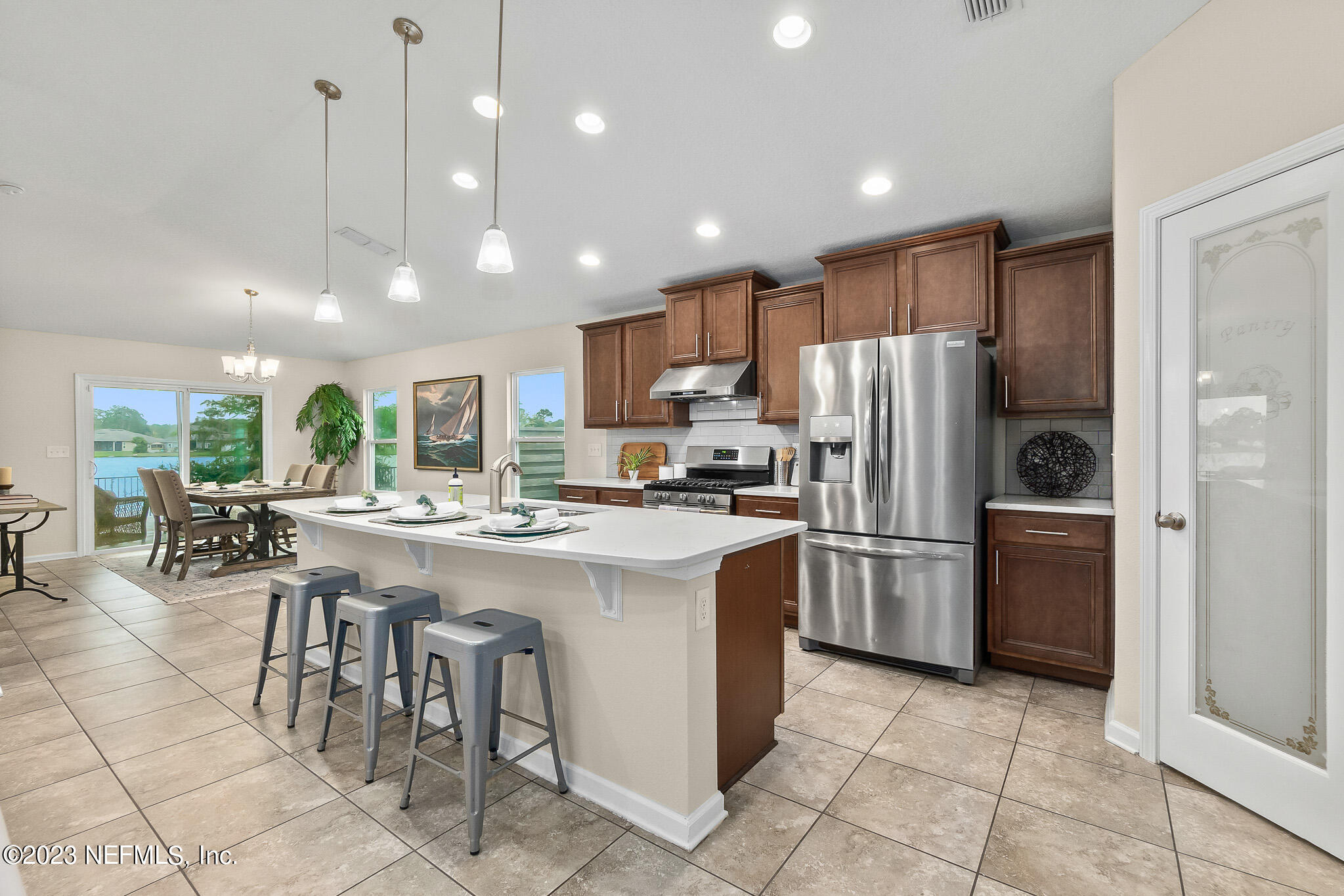 598 Deer Crossing Road St. Augustine, FL 32086 - Photo 10 of 33 a kitchen with stainless steel appliances granite countertop a refrigerator a stove a sink a oven with a dining table and chairs