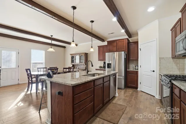 a kitchen with stainless steel appliances granite countertop a sink stove and refrigerator