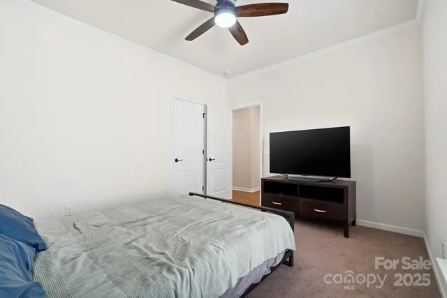 a bedroom with a bed and a flat tv screen on the dresser
