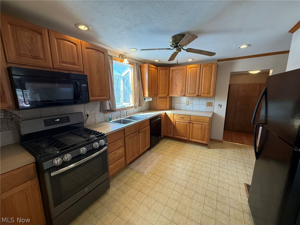 6784 Old Zoarville Road Northeast Dover, OH 44622 - Photo 13 of 50 Kitchen featuring black appliances, wood finish cabinetry, light countertops, ceiling fan, and backsplash