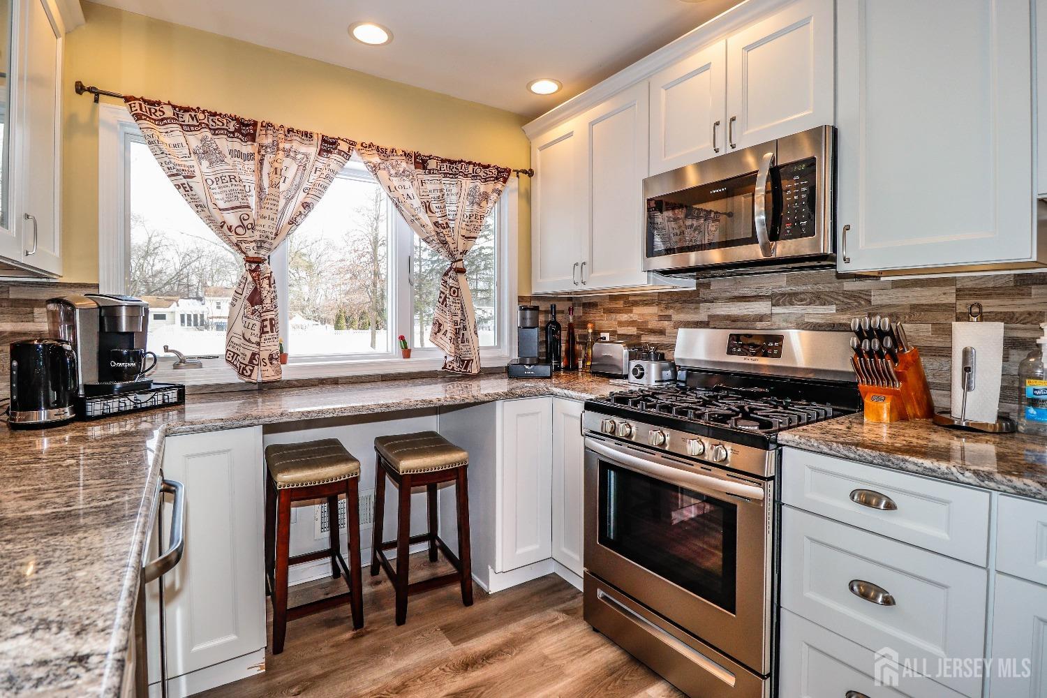 161 Devon Road Colonia, NJ 07067 - Photo 13 of 34 a kitchen with stainless steel appliances a stove a sink and a microwave