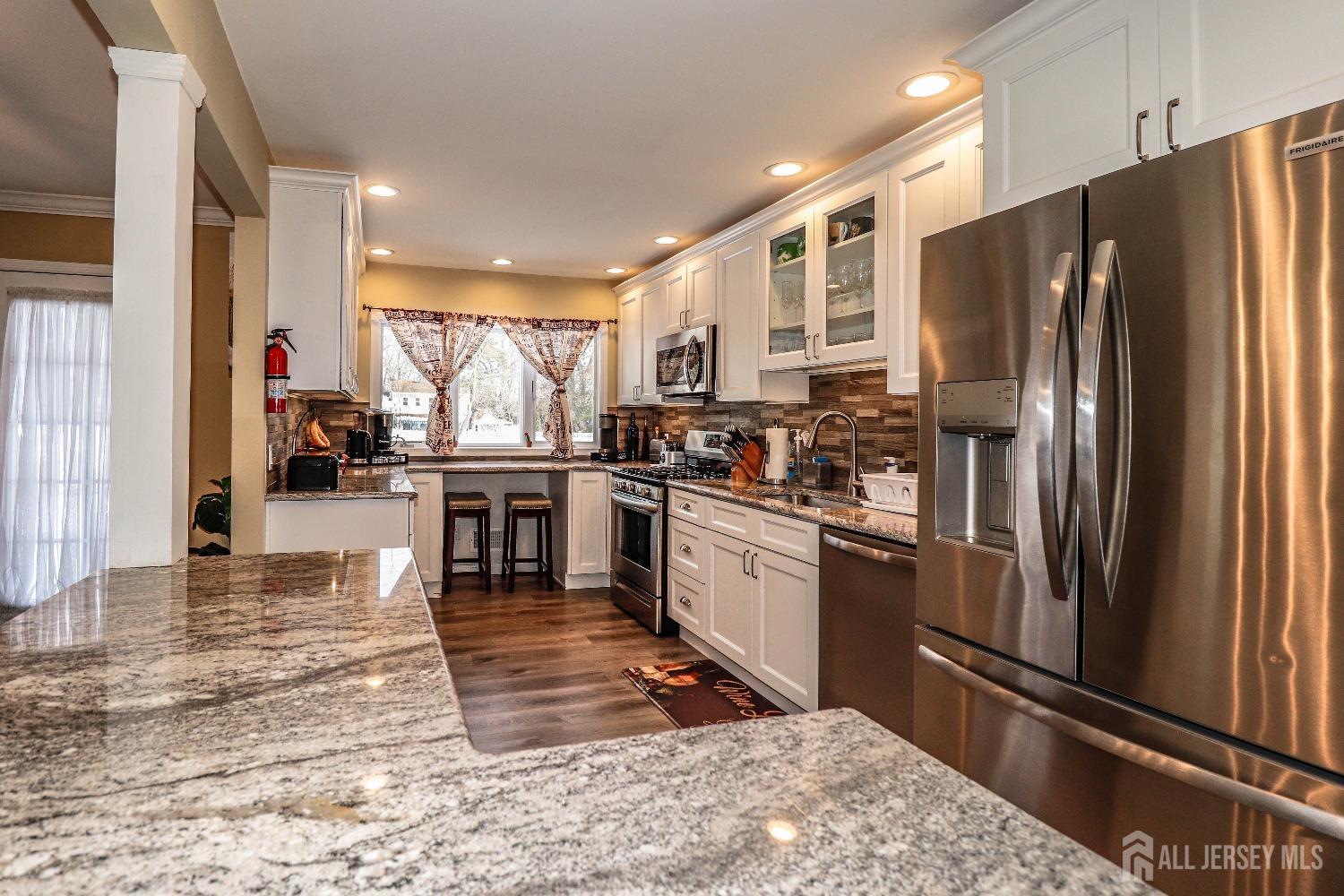 161 Devon Road Colonia, NJ 07067 - Photo 8 of 34 a kitchen with stainless steel appliances granite countertop a refrigerator a stove and a sink