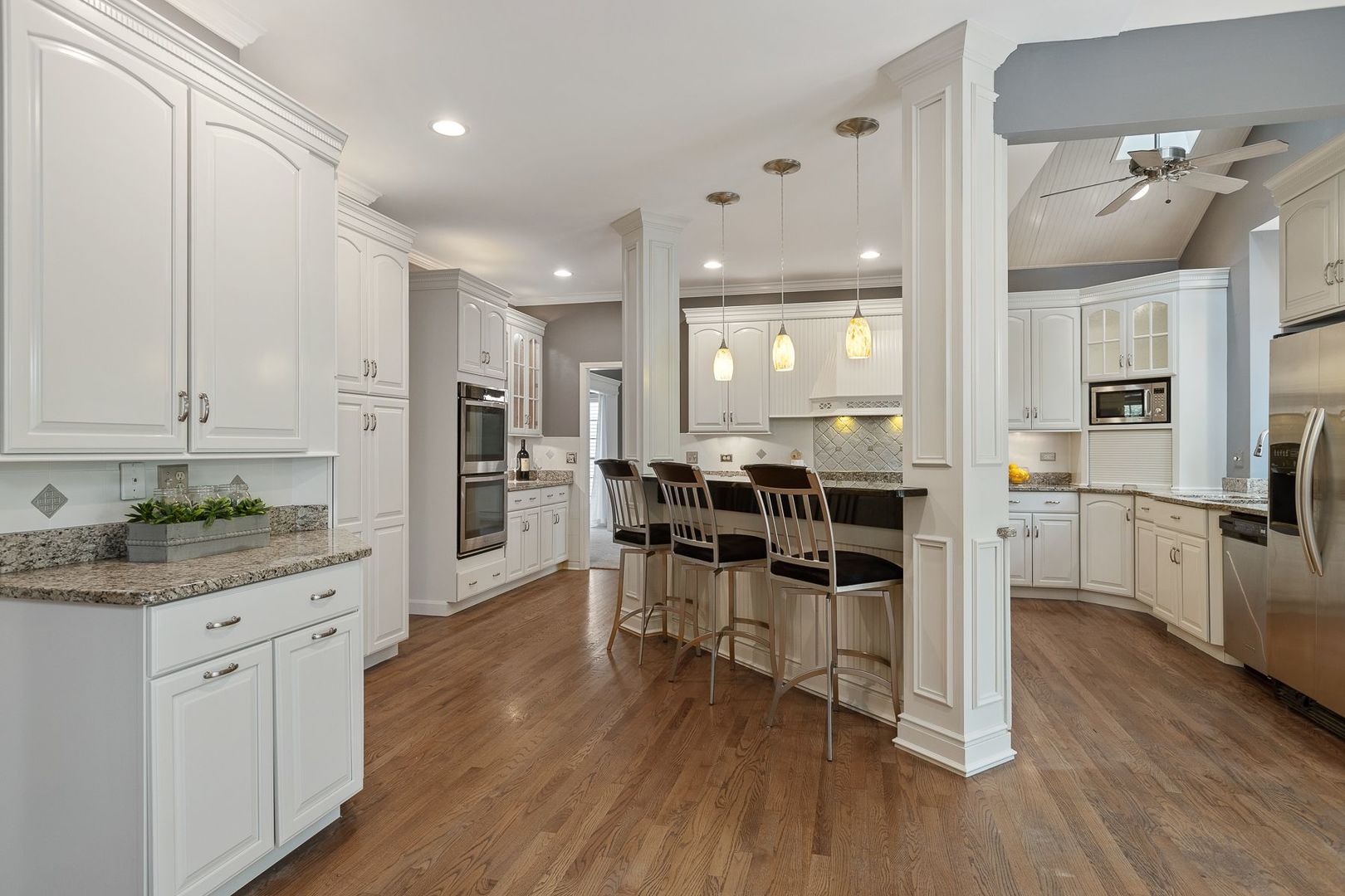 1540 West Wiesbrook Road Wheaton, IL 60189 - Photo 12 of 36 a living room with stainless steel appliances kitchen island granite countertop lots of wooden cabinets a sink a stove and a wooden floors
