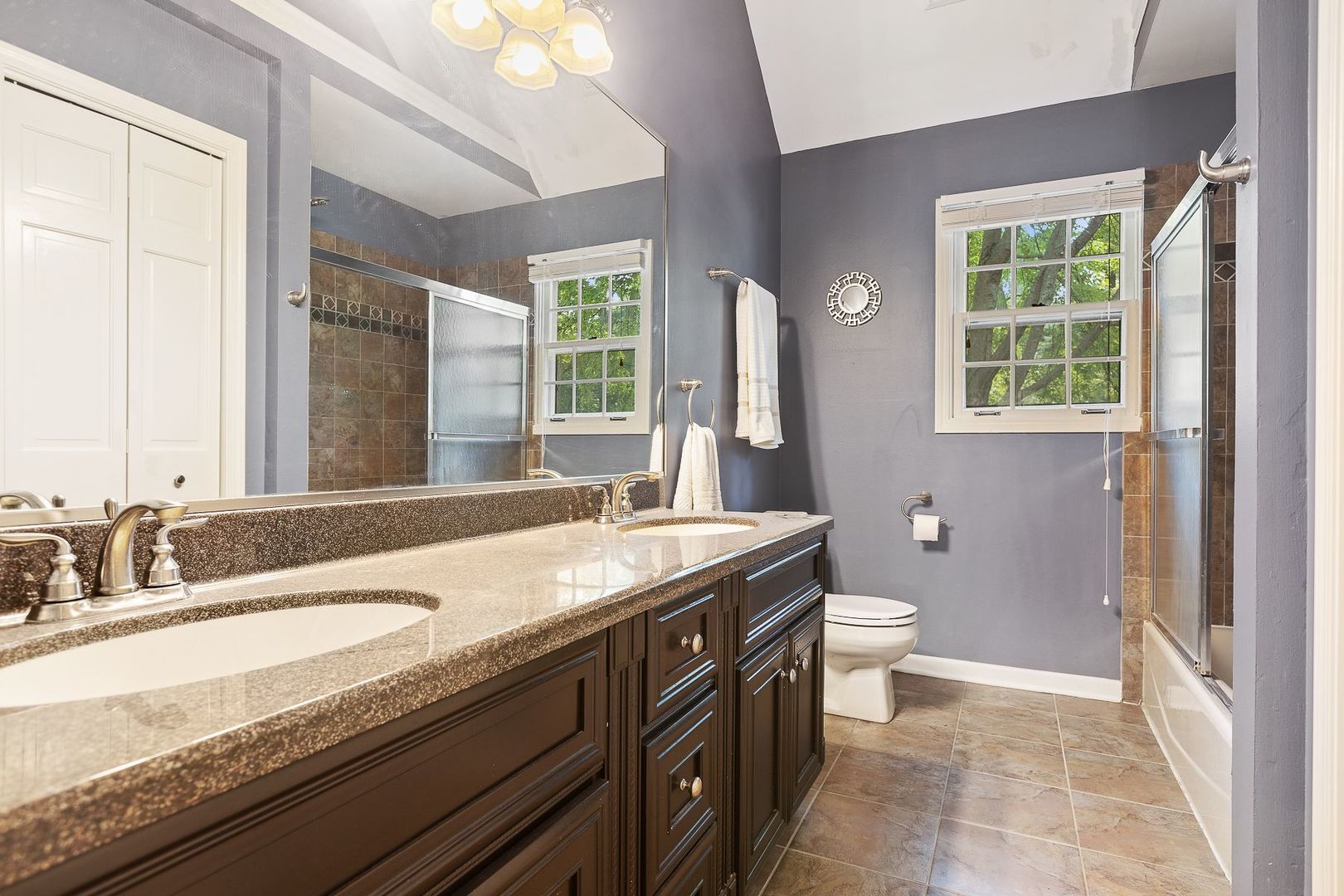 1540 West Wiesbrook Road Wheaton, IL 60189 - Photo 30 of 36 a bathroom with a granite countertop sink a toilet a large mirror and a window