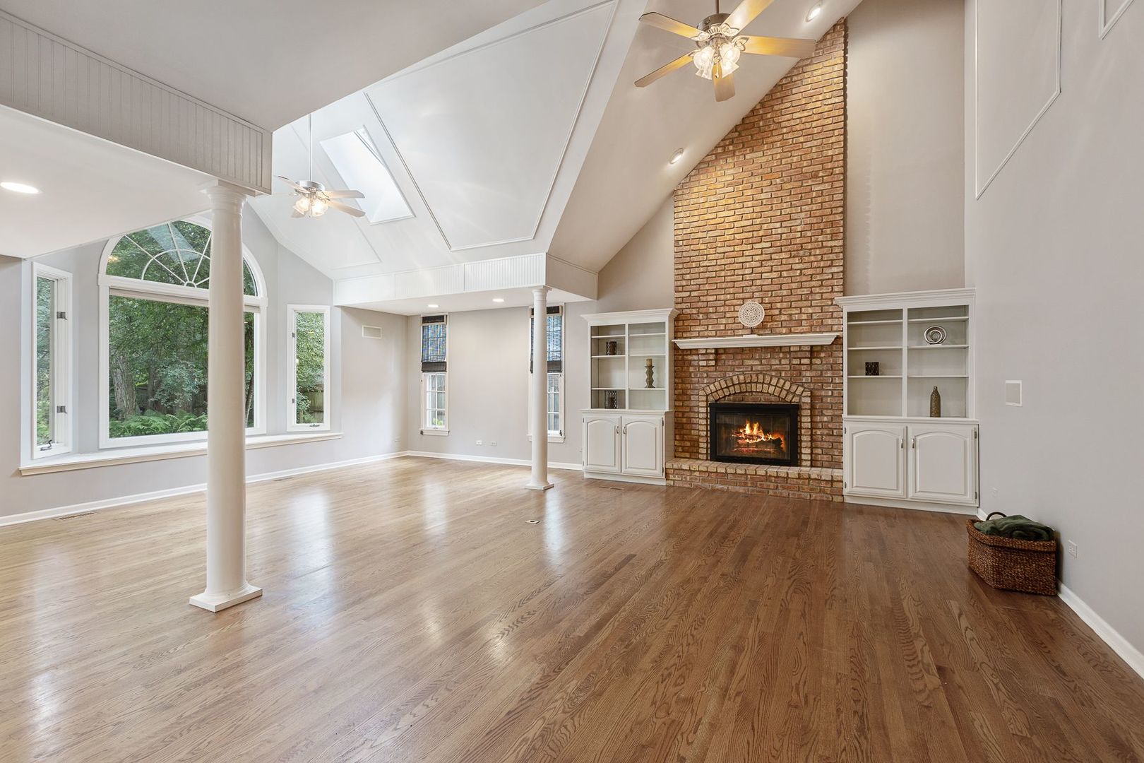 1540 West Wiesbrook Road Wheaton, IL 60189 - Photo 4 of 36 an empty room with wooden floor fireplace and windows