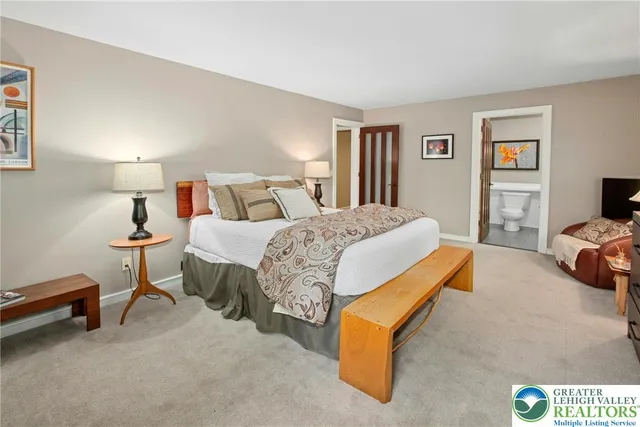 a bedroom with a bed and large windows