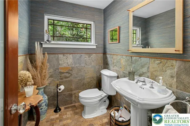 a front view of a house with trees and plants