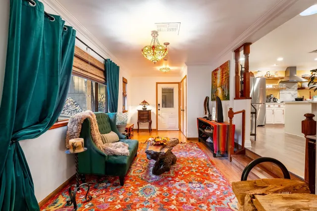 a kitchen with stainless steel appliances kitchen island granite countertop a table chairs in it and wooden floors