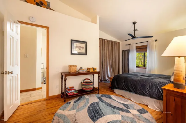 a view of a hallway with wooden floor and a bathroom