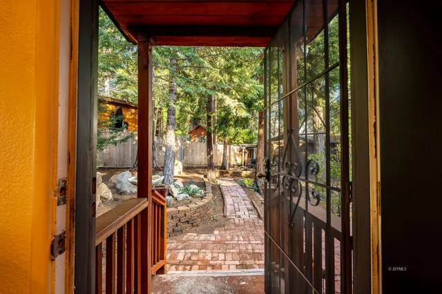 a view of a patio with table and chairs with wooden floor and fence
